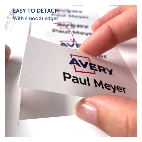 Изображение показывает руку, снимающую этикетку с листа, с именем «Paul Meyer» и логотипом «Avery», с примечанием, указывающим, что её легко отделить с гладкими краями.