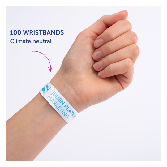 Изображение показывает руку человека с браслетом, на котором написано «100 WRISTBANDS Climate neutral», а также напечатано «JULIEN PLATTER MARKETING».