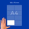 Рука рядом с листом формата A4 с сеткой и надписью «105 × 70 мм» на синем фоне?