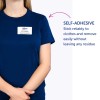 Изображение показывает человека в темно-синей рубашке с бейджем, на котором написано "Б. Карлос, ДИРЕКТОР ПО МАРКЕТИНГУ". Бейдж самоклеящийся, и имеется текст, объясняющий его свойства.