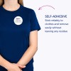 Изображение показывает человека в синей футболке с самоклеящимся бейджем, на котором написано: «Б. Карлос, маркетинговый директор». Текст подчёркивает, что бейдж надежно приклеивается к одежде и может быть легко удалён без следов.