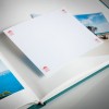 Изображение показывает открытый фотоальбом с пустой страницей, готовой для добавления фотографии. Альбом содержит изображения пляжа и морских пейзажей, при этом пустая страница представлена на видном месте.