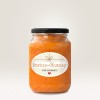 Изображение показывает банку с Kürbis-Chutney с декоративной этикеткой. Чатни имеет ярко-оранжевый цвет, а крышка банки черная. На этикетке на светлом фоне размещен текст 'Kürbis-Chutney für Gourmets'.