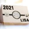 Изображение показывает открытку с указанием года 2021, текстом "FROHES NEUES" и именем "LISA". По обе стороны от центрального текста находятся мультяшные изображения котов.